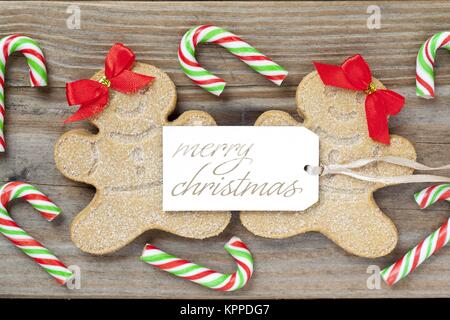 image of a female gingerbread candies with a merry christmas tag and candy canes Stock Photo