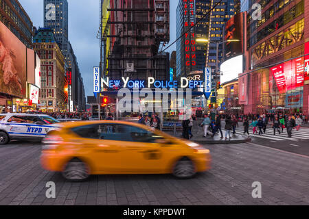 View of Times Square showing New York Police Dept (NYPD) office with yellow cab and people walking on pavement, New York, USA Stock Photo