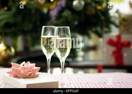 Christmas party drinking concept, glass of champagne with gift box on bokeh background Stock Photo