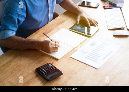 Calculate budget and business planning concept, people couting revenue and expenditure by using calculator and laptop  looking paper graph on desk in  Stock Photo