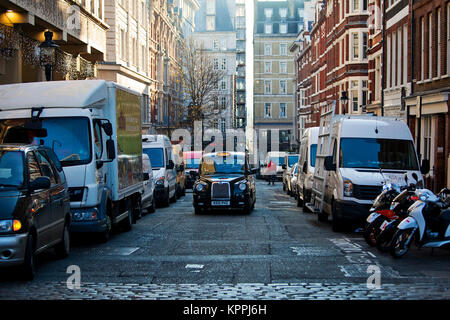 LONDON, UNITED KINGDOM - DECEMBER 12th, 2017: Iconic black taxi drives on the street of Central London, near Covent Garden. Stock Photo