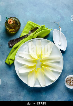 Belgian endive ready to be served - healthy food - cruet with olive oil, forks and spices Stock Photo