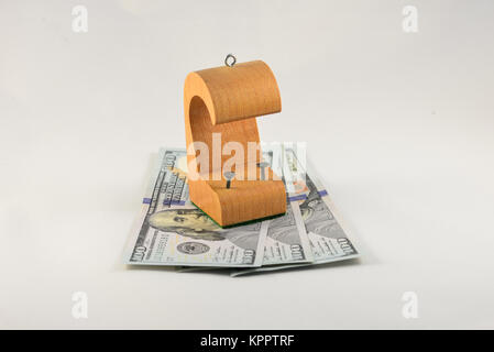 A wooden tack (tax) shelter sitting on three one hundred dollar US bills. Stock Photo