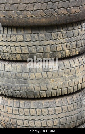 A pile of four used and worn tires ready for recycling. Stock Photo