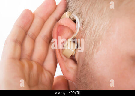 Close-up Of Man Wearing Hearing Aid In Ear Stock Photo