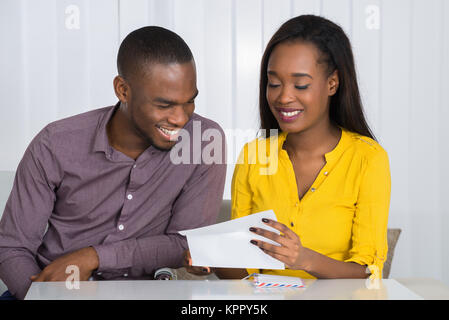 Young Couple Reading Letter Stock Photo