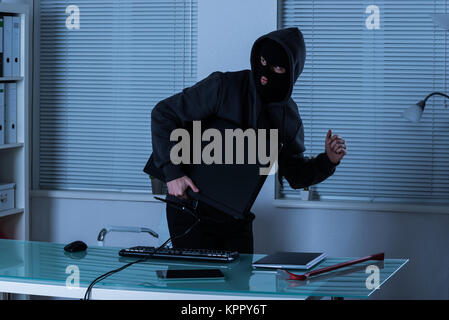 Thief Stealing Computer From Office Stock Photo