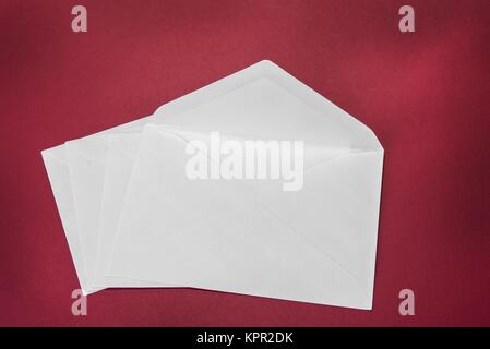 One opened white envelope on the red background Stock Photo