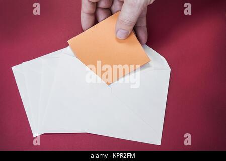 One opened white envelope on the red background Stock Photo