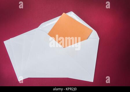 One opened white envelope on the red background Stock Photo