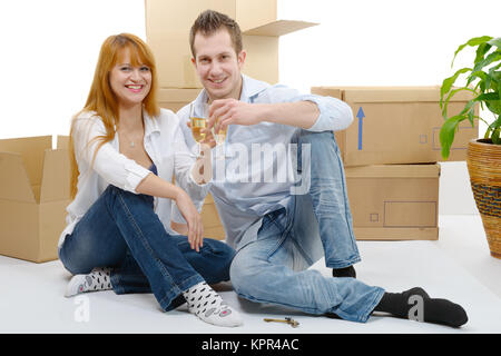 couple celebrating their new home,  and champagne in hand. Stock Photo