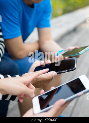 Friends using cellphone together Stock Photo