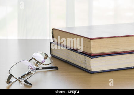Book and Eyeglasses on a wood table Stock Photo