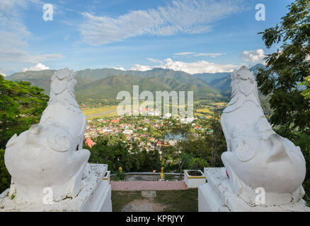 Lion statue at Wat Phra That Doi Kong Mu with city view of Mae Hong Son in Thailand Stock Photo