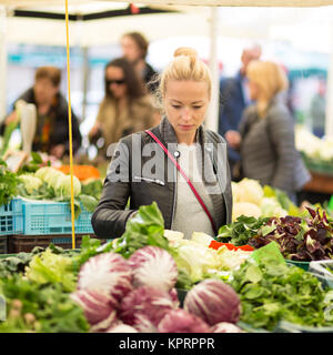 Woman buying vegetable at local food market. Stock Photo