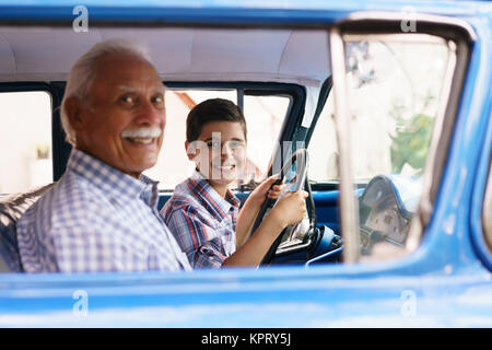 Portrait Grandpa Giving Driving Lesson To Boy In Old Car Stock Photo