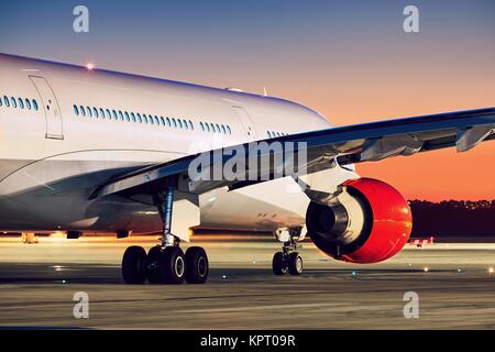 Airplane on the runway. Airport at the amazing sunset. Stock Photo