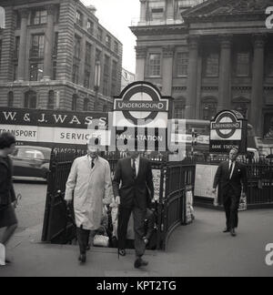 1950s, London, two city gentlemen wearing bowler hats emerge from the narrow exit at Bank Underground Station in the City of London, England, UK. Stock Photo