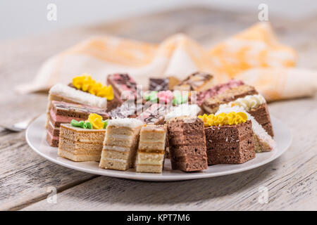 Small cakes with different stuffing on white plate Stock Photo