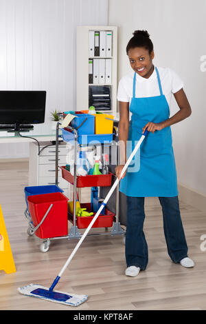 Cleaning Sign And Woman Mopping Floor In Office For Hygiene Health