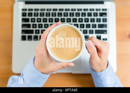 Top view of woman drinking coffee on working desk Stock Photo