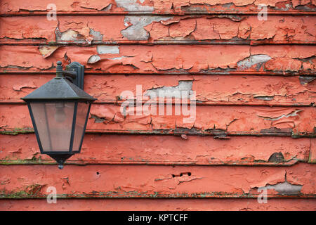 Street lamp mounted on grungy red wooden wall Stock Photo