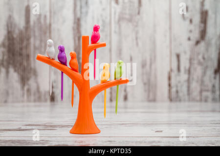 Creative plastic kitchen tool. Fruit or dessert bird toothpicks on tree shaped stand holder Stock Photo