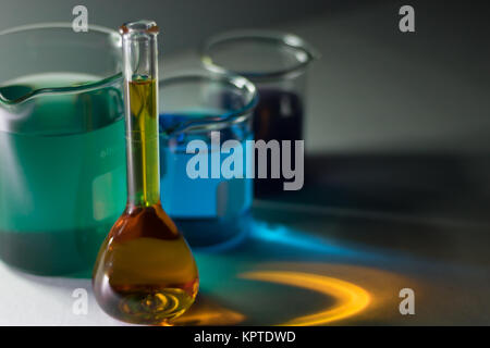 Laboratory glassware with liquid chemicals isolated over gray background Stock Photo