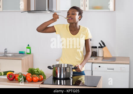 Woman Cooking Meal In Kitchen Stock Photo