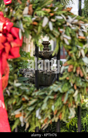 A stone garden fountain framed by a Christmas wreath on Meeting Street in Charleston, SC. Stock Photo