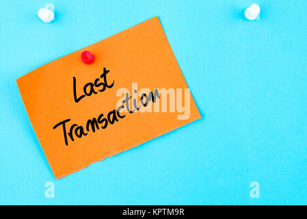 Last Transaction written on orange paper note pinned on cork board with ...