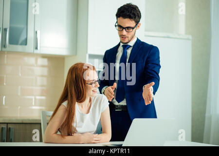 Two analysts discussing online data in front of laptop Stock Photo