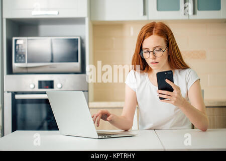 young business woman is using a smartphone and smiling while working in office Stock Photo