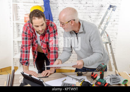 two technicians read a plan in the workshop Stock Photo