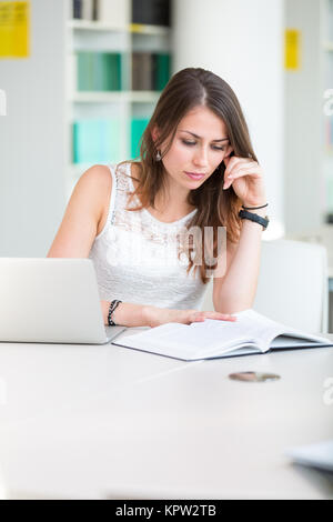 Pretty young college student in a library (shallow DOF  color toned image) Stock Photo