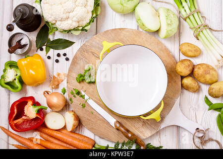 High Angle Still Life View of Cutting Board, Knife and Wok Frying Pan Surrounded by Fresh Raw Vegetables on Painted Wood Table - Preparing a Meal with Raw Ingredients Stock Photo