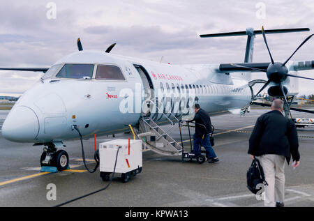 People boarding small Air Canada Jazz Express propeller airplane at Victoria International Airport, British Columbia, Canada 2017 Stock Photo