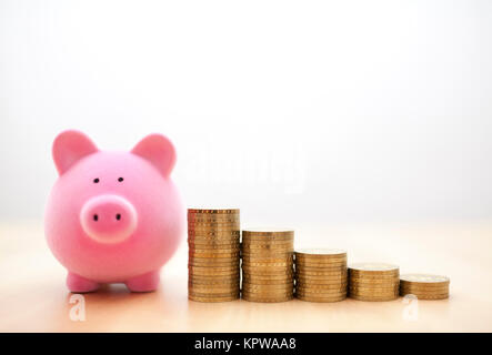 Pink piggy bank and coins Stock Photo