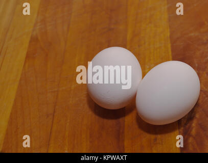 Two white eggs on a wooden table Stock Photo