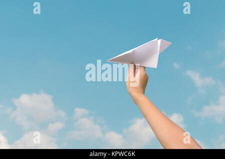 plane paper in children hand and blue sky Stock Photo