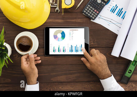 engineer using tablet checking business graph on work table Stock Photo