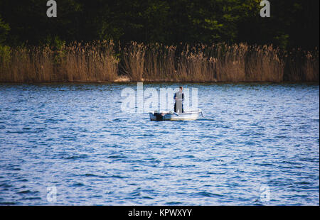 angler in small boat on mueggelsee Stock Photo