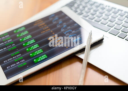 Stock market graph with tablet pc and laptop Stock Photo