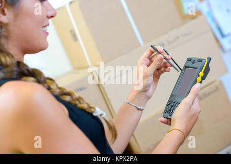 Lady signing for delivery using electronic device Stock Photo