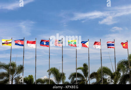 National flags of countries who are member of AEC (ASEAN economic community) over palm tree on blue sky background Stock Photo