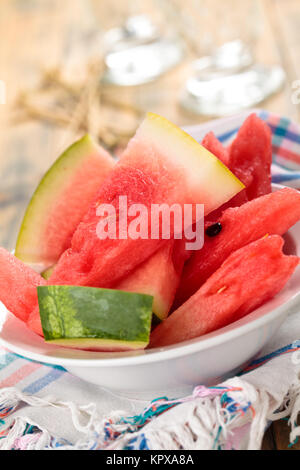 Closeup shot of fresh sliced watermelon in plate. On rustic wooden table.