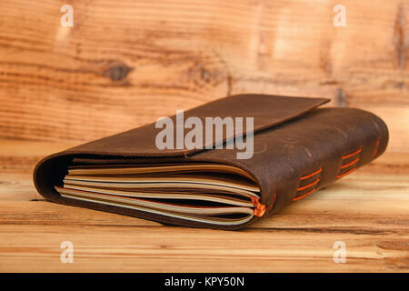 Notebook in leather cover on wooden table Stock Photo