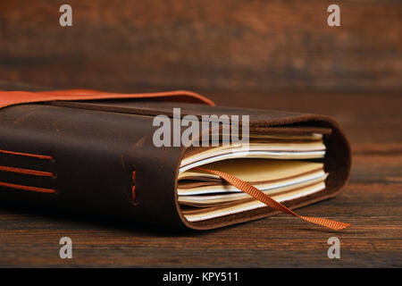 Notebook in leather cover on wooden table Stock Photo