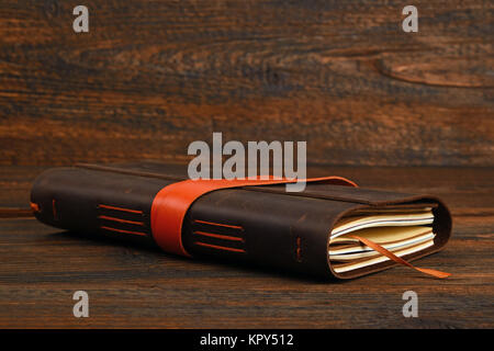 Notebook in leather cover on wooden table Stock Photo