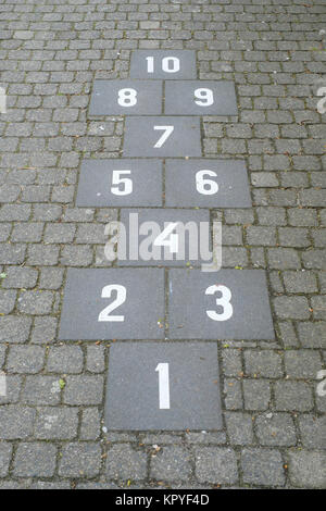 Hopscotch court with numbers from 1 to 10 drawn with white paint on the sidewalk Stock Photo